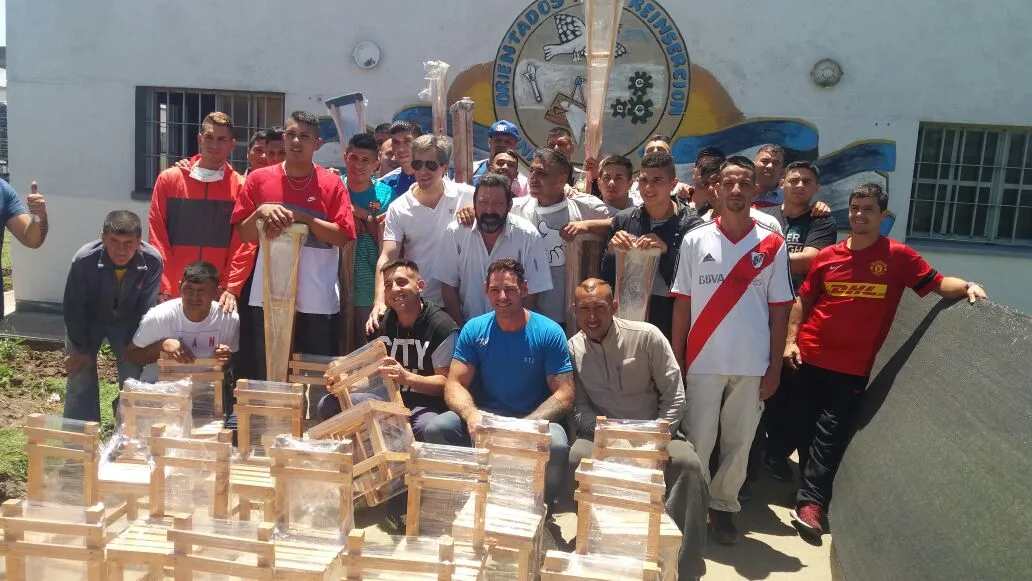 Participantes de los talleres junto a las sillas y muletas que fabricaron